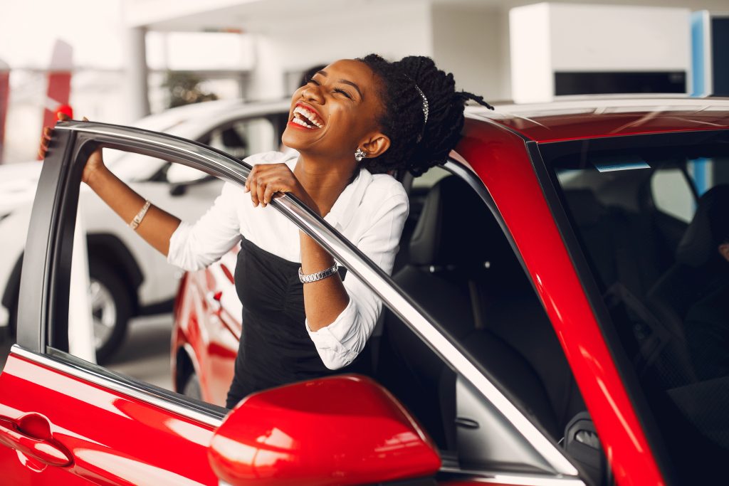stylish black woman in a car salon